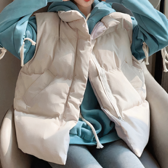 Das Bild ist in zwei Hälften geteilt und zeigt dieselbe junge Frau sitzend, die eine beigefarbene, ärmellose Daunenjacke aus der Schwangerschaft über einem blauen Kapuzenpullover trägt.