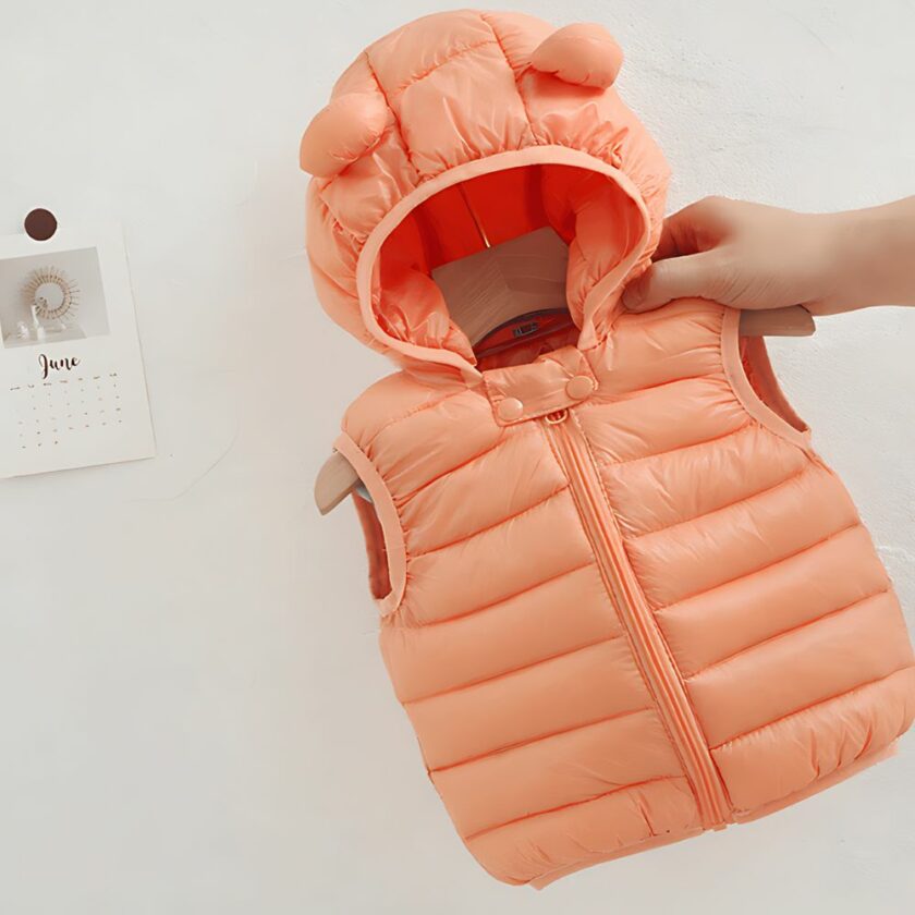 Ärmellose rosafarbene Daunenjacke mit Kapuze für Kinder auf weißem Hintergrund.