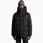 sie sehen einen jungen Mann mit einer dicken schwarzen Daunenjacke für Männer stehen