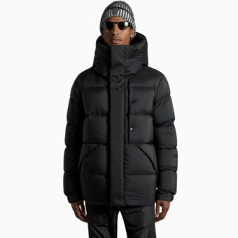 sie sehen einen jungen Mann mit einer dicken schwarzen Daunenjacke für Männer stehen
