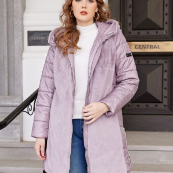 Offene violette Daunenjacke mit kurzem Pelz auf der Vorderseite und Steppung an den Ärmeln. Sie wird von einer Frau mit langem, welligem, offenem Haar getragen, die darunter einen weißen Pullover und eine zerrissene blaue Jeans auf den Knien hat. Im Hintergrund befindet sich eine Treppe mit einer großen schwarz-goldenen Tür.