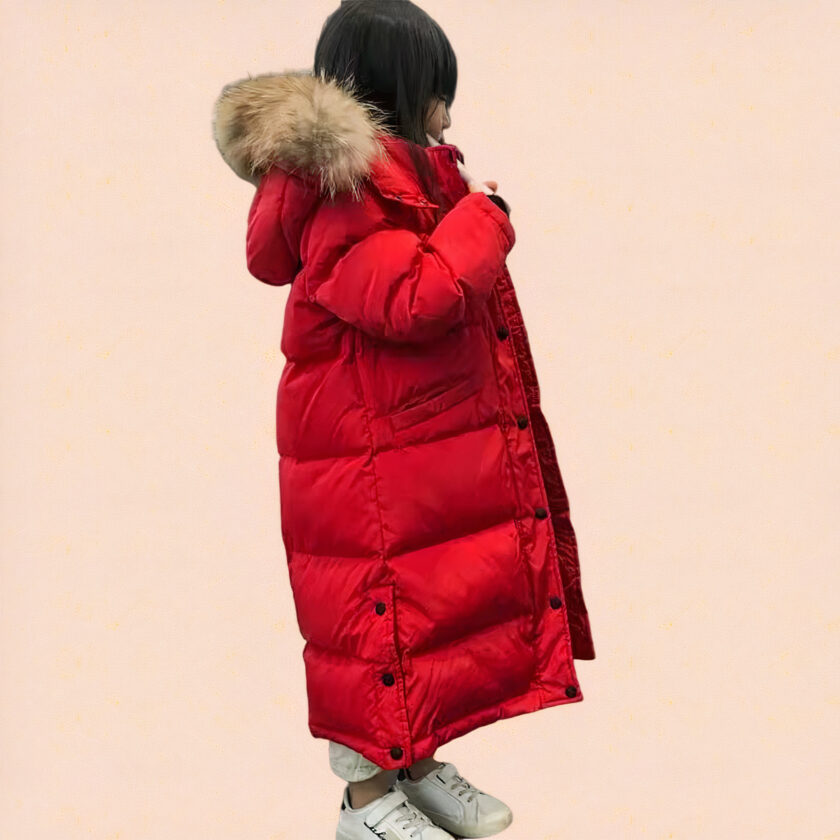 Kleines Mädchen mit einer roten Kinder-Kapuzenjacke auf rosafarbenem Hintergrund.