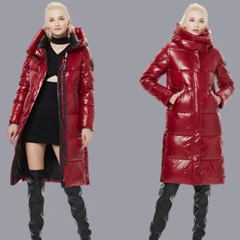 Eine junge blonde Frau trägt eine lange, rot lackierte, gesteppte Daunenjacke für Frauen. Links ist sie offen und rechts geschlossen und ihre Hände sind in den Taschen, auf einem cremeweißen Hintergrund.