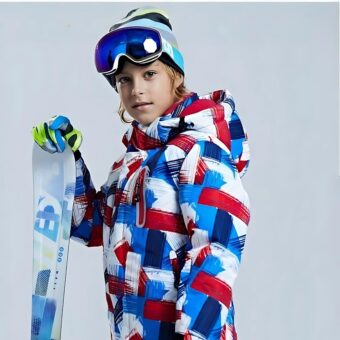 Ski-Daunenjacke für Kinder, die von einem Kind mit einem Skihelm und Skiern im rechten Handschuh getragen wird.