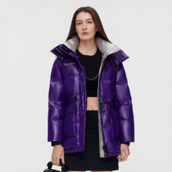 Brünette Frau, die eine offene violette Daunenjacke und darunter schwarze Kleidung trägt.
