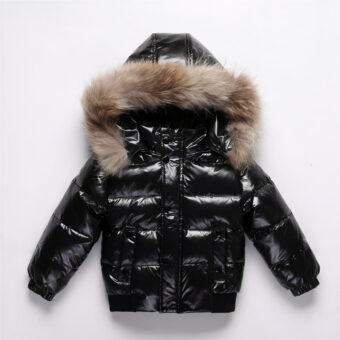Schwarze, warme und dicke Daunenjacke mit Kapuze für Mädchen auf grauem Hintergrund.