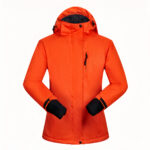 Orangefarbene Ski-Daunenjacke mit schwarzen Bündchen.